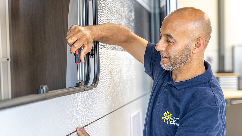 Mann baut Ausstellfenster ein